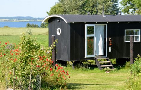Un mobile home noir et blanc placé dans le jardin