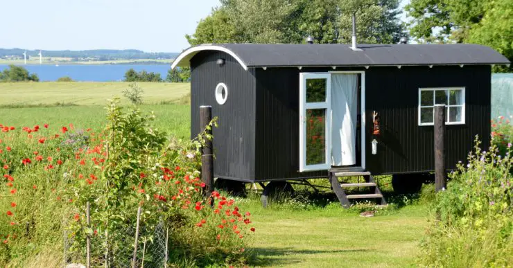 Un mobile home noir et blanc placé dans le jardin