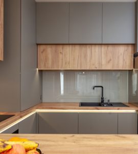 Une cuisine moderne grise avec des meubles en bois