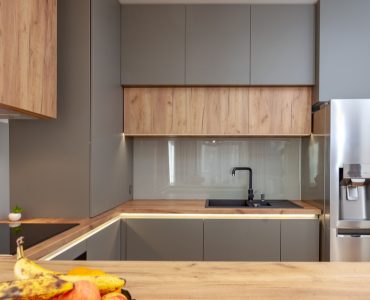 Une cuisine moderne grise avec des meubles en bois