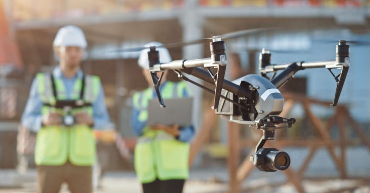 Deux spécialistes utilisent un drone sur le chantier