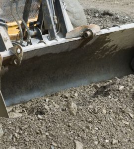 Une pelle mécanique ramassant le gravier lors de travaux de terrassement