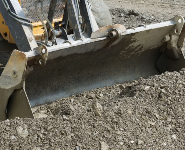 Une pelle mécanique ramassant le gravier lors de travaux de terrassement