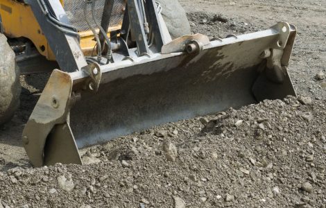 Une pelle mécanique ramassant le gravier lors de travaux de terrassement