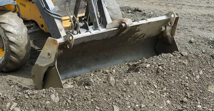 Une pelle mécanique ramassant le gravier lors de travaux de terrassement