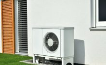 Une pompe à chaleur installée à l'extérieur d'un bâtiment gris