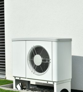 Une pompe à chaleur installée à l'extérieur d'un bâtiment gris