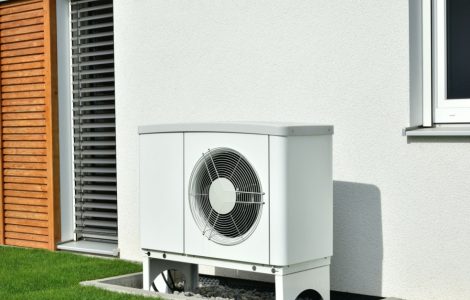 Une pompe à chaleur installée à l'extérieur d'un bâtiment gris