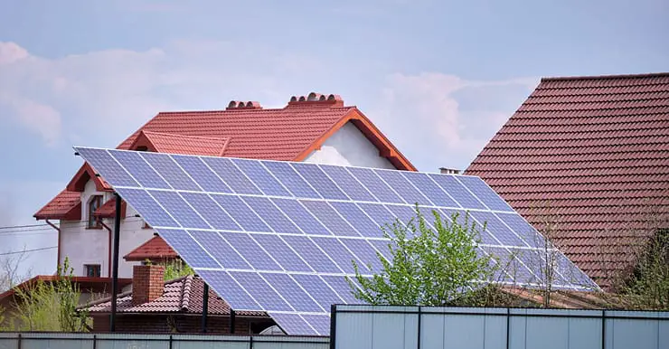 Une maison avec plusieurs panneaux solaires photovoltaïques montés sur un cadre incliné