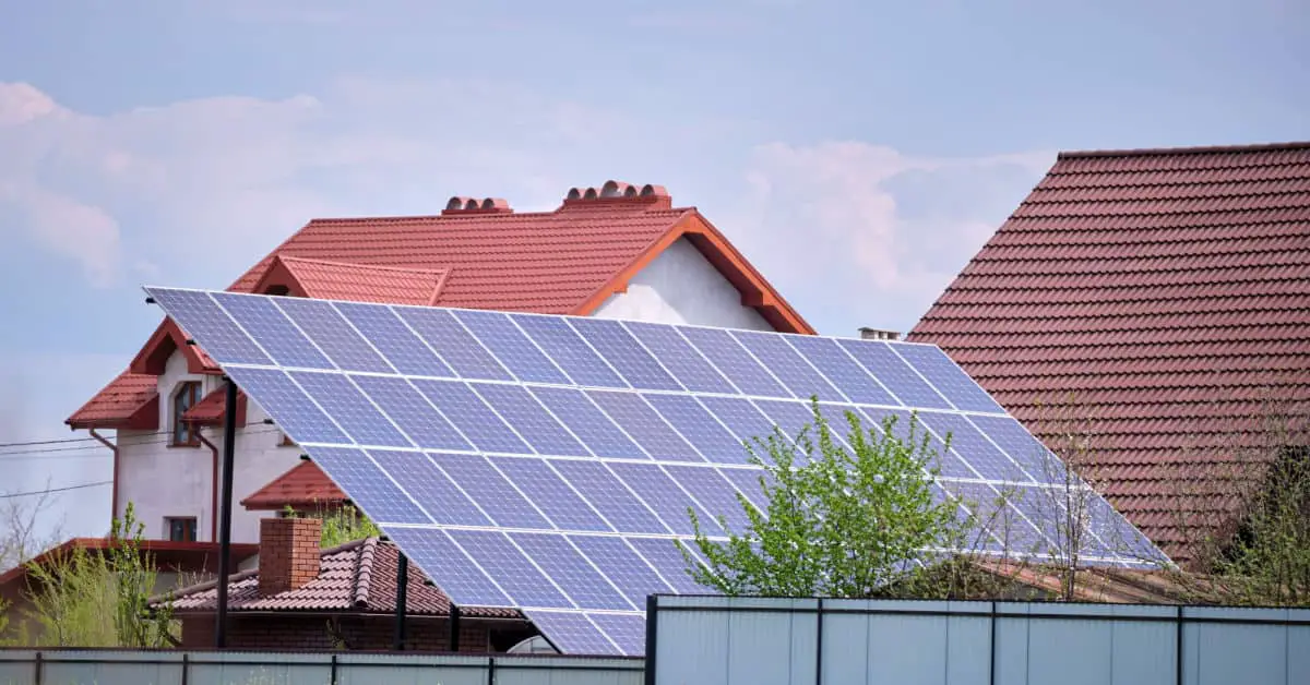 Une maison avec plusieurs panneaux solaires photovoltaïques montés sur un cadre incliné