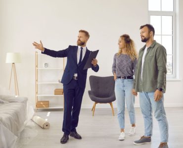 Un agent immobilier qui présente l'intérieur d'une maison à des acheteurs ou des locataires potentiels