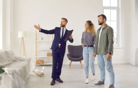 Un agent immobilier qui présente l'intérieur d'une maison à des acheteurs ou des locataires potentiels