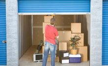 Un homme fermant le volet roulant d’un box de stockage