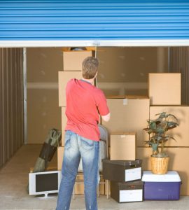 Un homme fermant le volet roulant d’un box de stockage