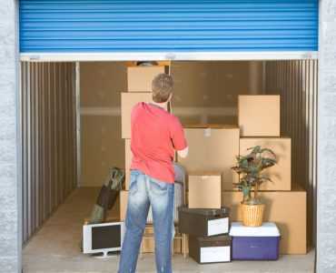 Un homme fermant le volet roulant d’un box de stockage