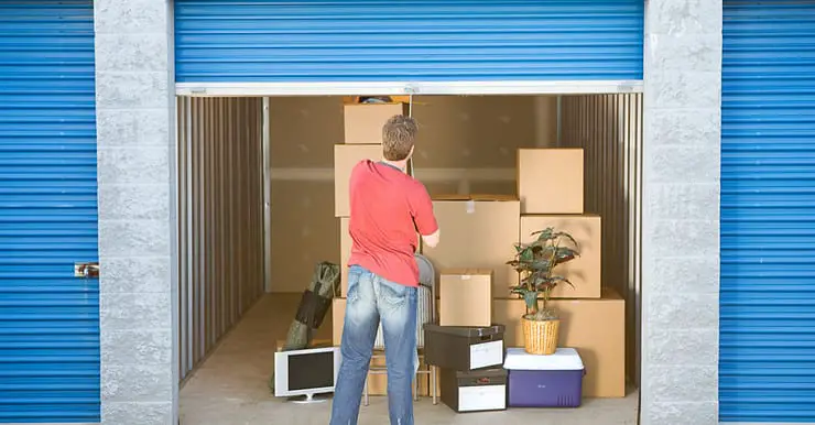 Un homme fermant le volet roulant d’un box de stockage