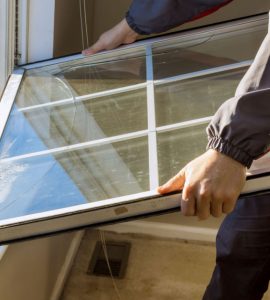 Un homme en train de remplacer une fenêtre de sa maison