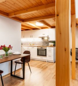 Une table à manger pour deux personnes sous l’étage construit en bois