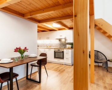 Une table à manger pour deux personnes sous l’étage construit en bois