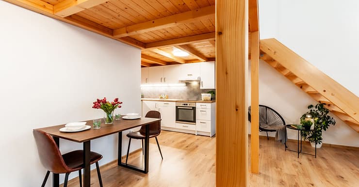 Une table à manger pour deux personnes sous l’étage construit en bois