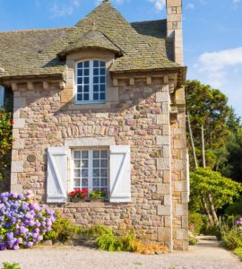 Vue sur une maison en pierre entourée de verdure