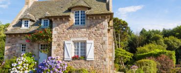 Vue sur une maison en pierre entourée de verdure