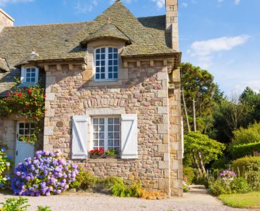 Vue sur une maison en pierre entourée de verdure