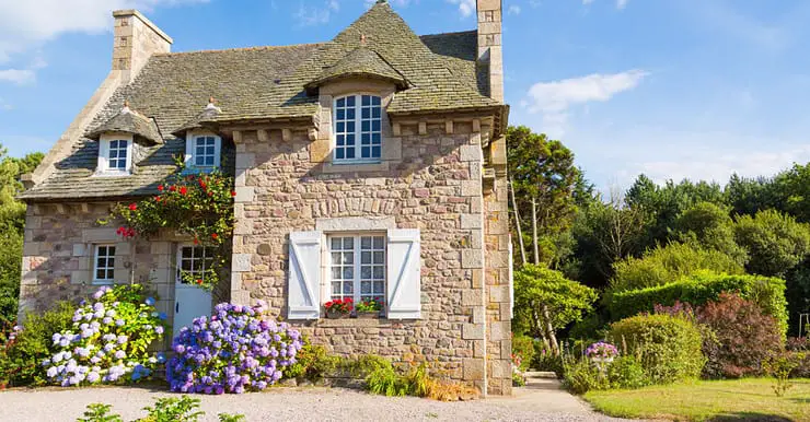 Vue sur une maison en pierre entourée de verdure