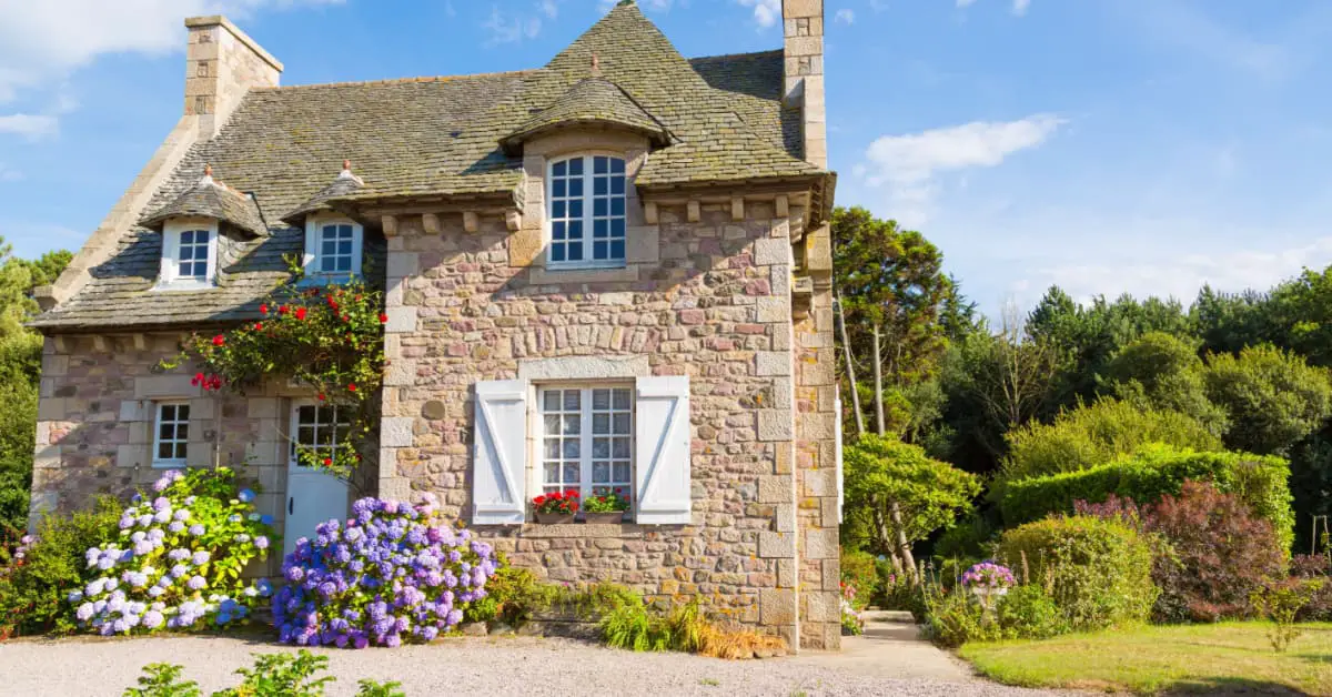 Vue sur une maison en pierre entourée de verdure