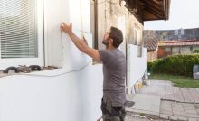 Un homme en train d’installer l'isolation thermique de la façade