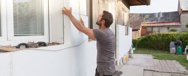 Un homme en train d’installer l'isolation thermique de la façade