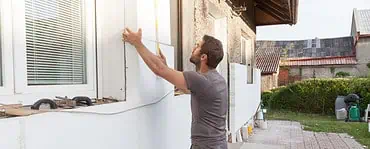 Un homme en train d’installer l'isolation thermique de la façade