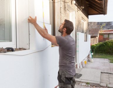 Un homme en train d’installer l'isolation thermique de la façade