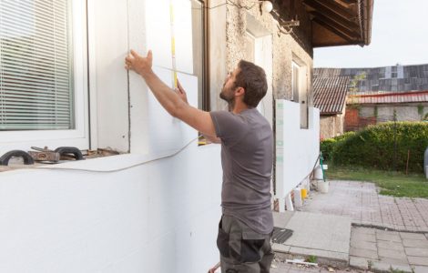 Un homme en train d’installer l'isolation thermique de la façade
