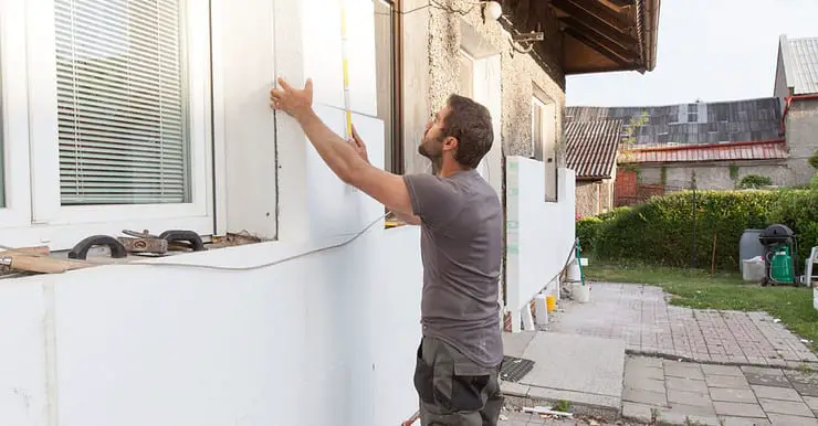 Un homme en train d’installer l'isolation thermique de la façade