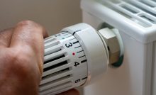Gros plan sur la main d'un homme régulant la température avec le thermostat