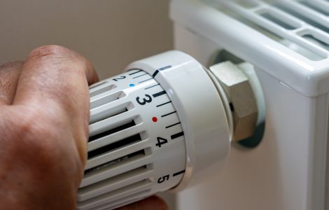 Gros plan sur la main d'un homme régulant la température avec le thermostat