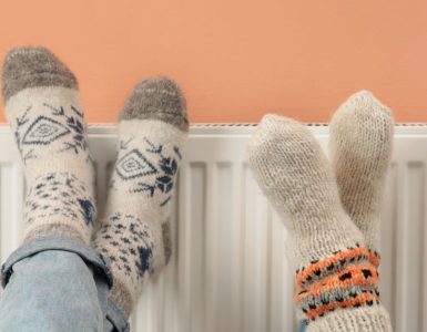 Deux personnes croisent les jambes sur le chauffage de la maison