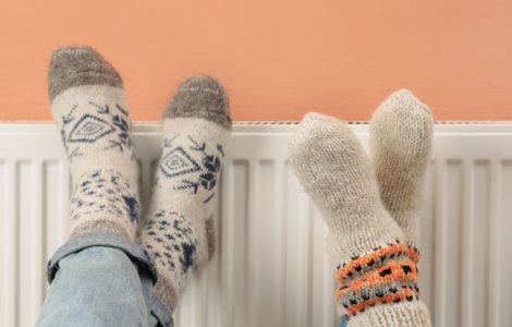 Deux personnes croisent les jambes sur le chauffage de la maison
