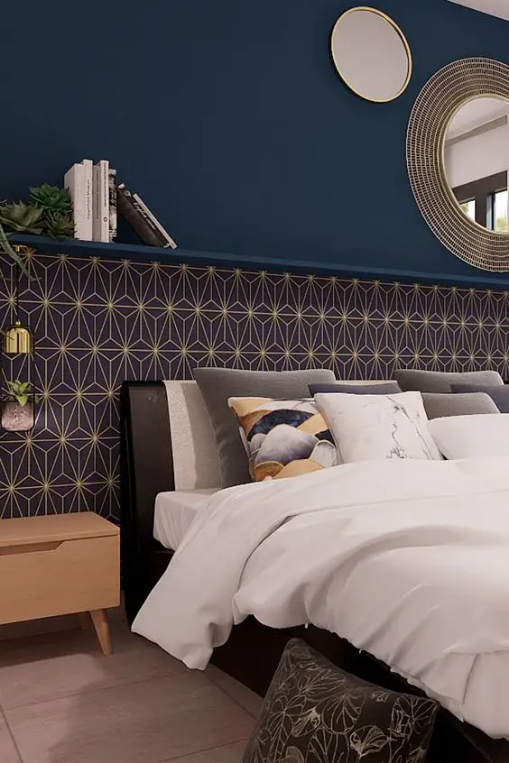 Posé sur la tête de lit, le papier peint aux motifs Art Déco s’associe parfaitement avec la peinture bleue choisie