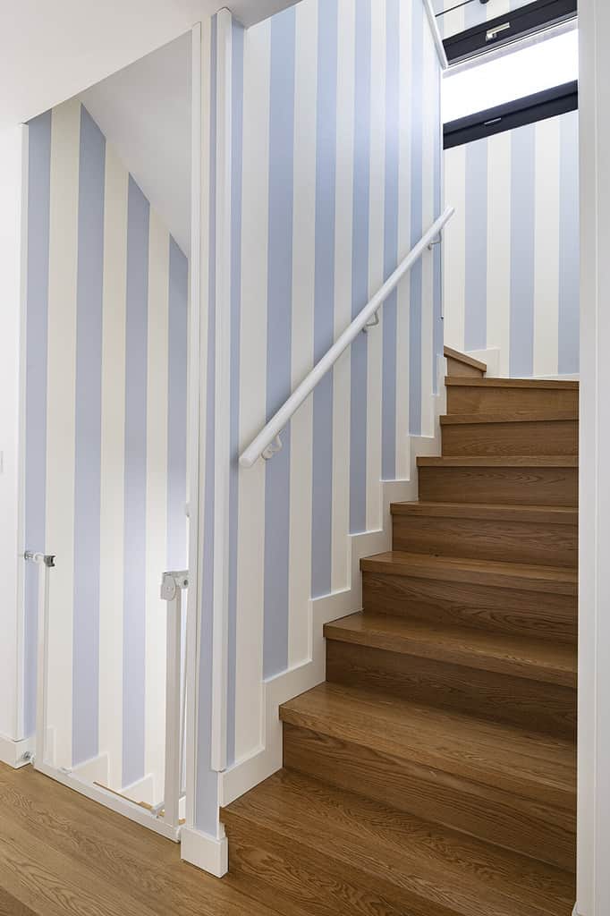 escalier en bois et papier peint bleu et blanc