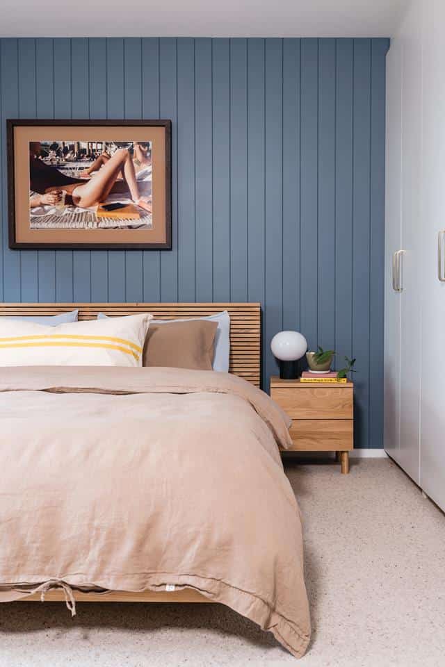 chambre d'adultes avec fond bleu et lit en bois