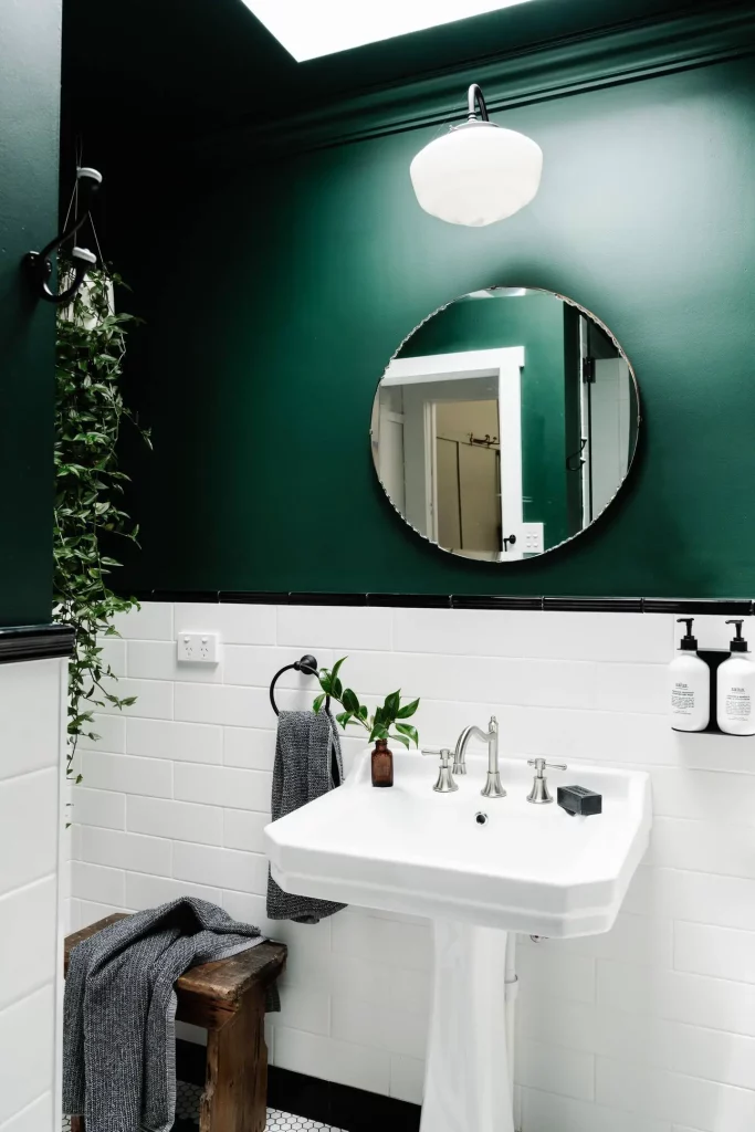 mur vert et miroir rond dans la salle de bain