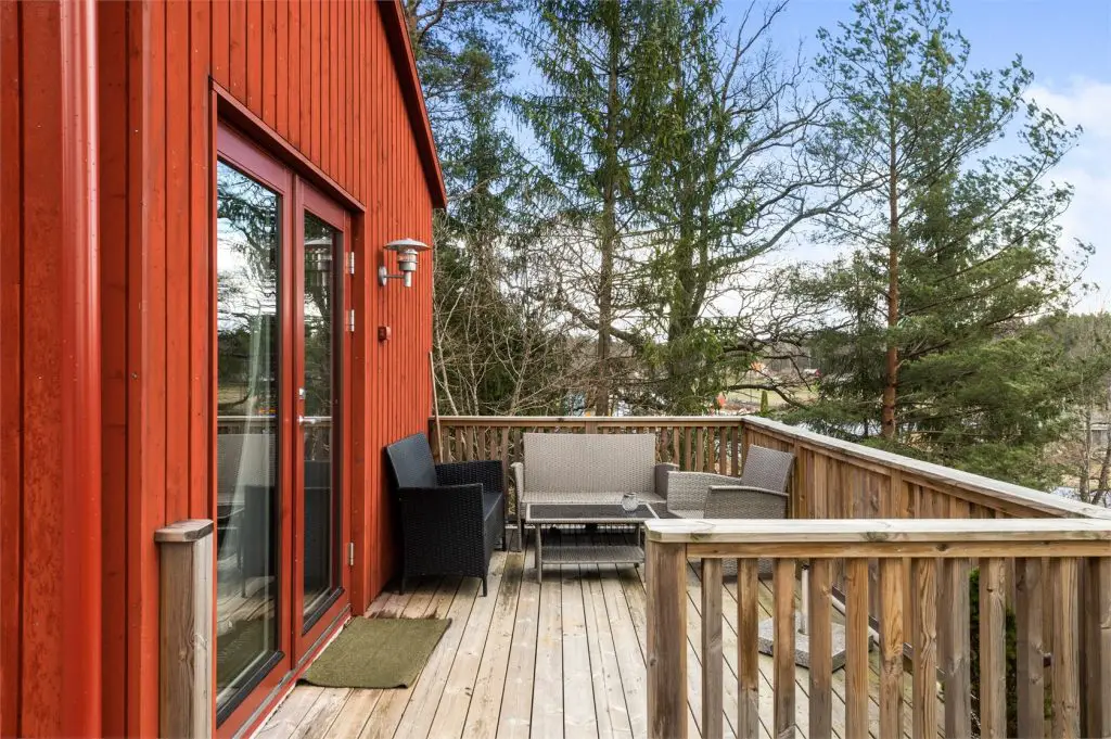 façade extérieure rouge et terrasse en bois