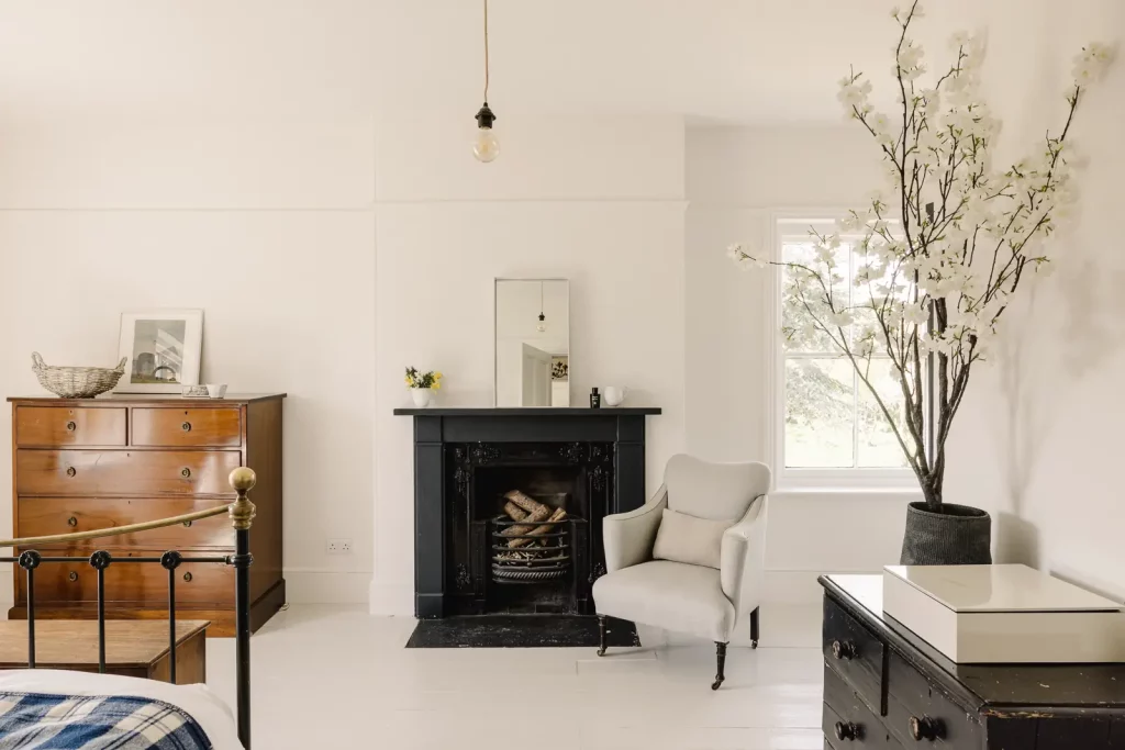 chambre aux murs blancs et sa cheminée