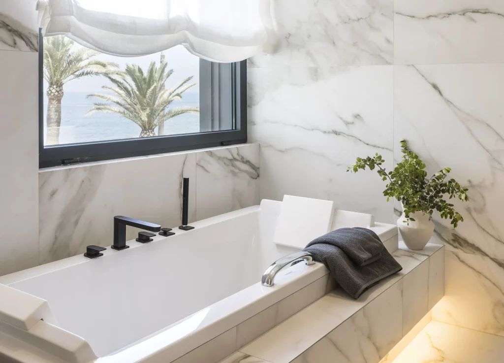 salle de bain entourée de marbre sous la fenêtre
