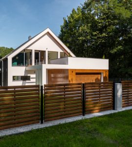 Cette clôture en bois, aux lattes ajourées, contribue au style contemporain de cette superbe maison