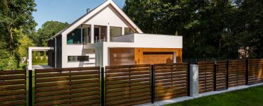 Cette clôture en bois, aux lattes ajourées, contribue au style contemporain de cette superbe maison