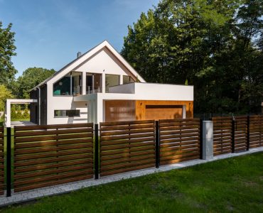 Cette clôture en bois, aux lattes ajourées, contribue au style contemporain de cette superbe maison