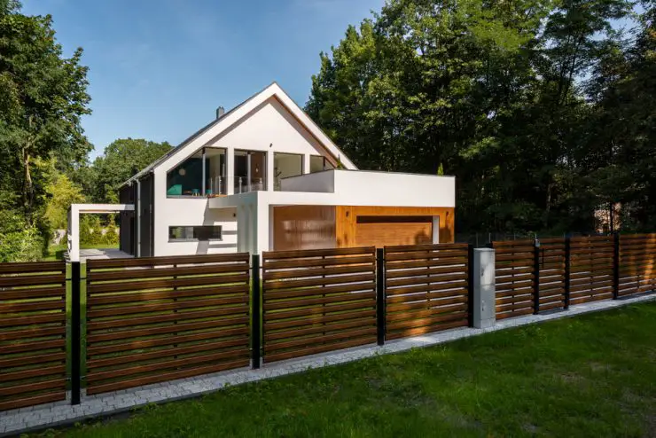 Cette clôture en bois, aux lattes ajourées, contribue au style contemporain de cette superbe maison